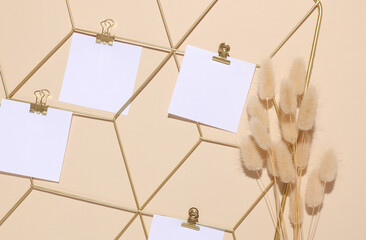 White square memo cards mockups attached to gold grid mood board and lagurus flowers on beige...