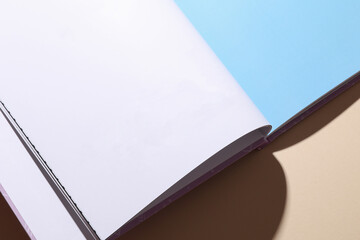 Blank page of open book or magazine on a beige background. Mockup for design
