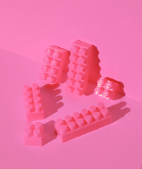 Toy bricks constructor on a pink background. Creative layout