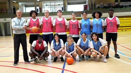 Basketball team posing with coach in gymnasium - Powered by Adobe