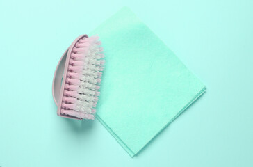 Brush with a rag on blue background. Cleaning concept