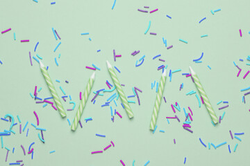 Birthday candles with  sprinkles on pastel background. Minimalism party concept