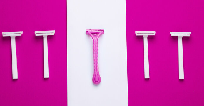 Disposable plastic razors on pink white background, minimalism beauty still lefe. Top view. Creative layout