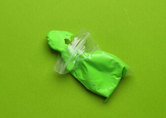 Air plasticine in open pack, green background. Children's creativity. Top view