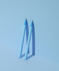 Plastic pens on blue background. Business, education concept. Creative layout, minimalism. Modern art