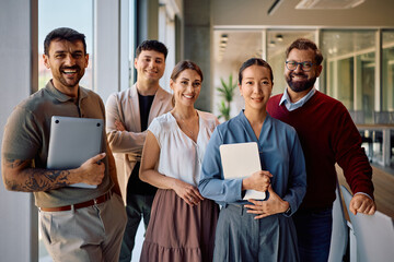 Happy diverse business coworkers in office looking at camera.
