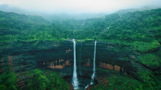 4K aerial shot of Kataldhar waterfall flowing from Sahyadri hills in Maharashtra, India. Monsoon background. Lush green landscape.