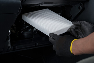 New cabin air filter being installed in a car.