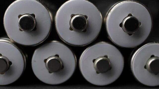 Close-Up View of Rechargeable Batteries Lined Up in Dark Environment Highlighting Charging Process