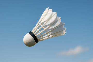 Feathered Shuttlecock Floating in Clear Blue Sky During Outdoor Match

