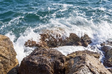 Coastal foamy waves crashing on the rocks on the Athens promenade