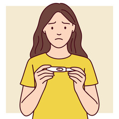 Sad woman in yellow shirt holds a negative pregnancy test. Represents disappointment, emotional pain, and fertility struggle