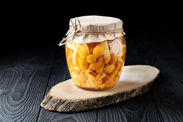 Jar of Pickled Mushrooms on Rustic Wooden Background