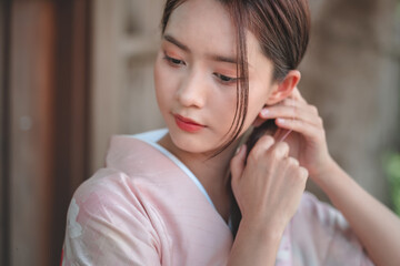 Young Woman Adjusting Hairstyle in Traditional Japanese Kimono