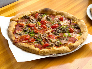 Delicious homemade pizza with toppings on wooden table