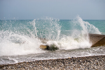 The ocean is crashing against the rocks, creating a powerful and dynamic scene
