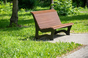A wooden bench sits in a grassy park