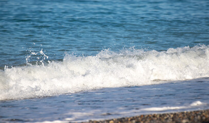 The ocean waves are crashing onto the shore, creating a beautiful