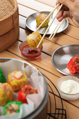 Dipping Dimsum Siomay to a Bowl with Chilli Oil