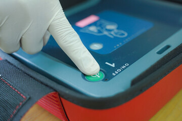 pressing the AED power button to turn it on and use a patient in cardiac arrest