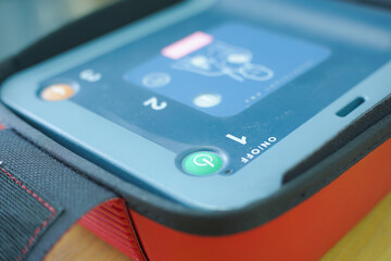 pressing the AED power button to turn it on and use a patient in cardiac arrest