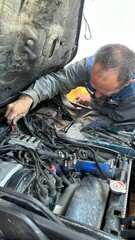 male mechanic repairing car engine