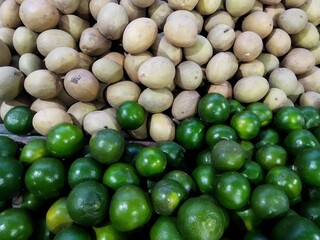 A pile of sapodilla fruit and squeezed orange.