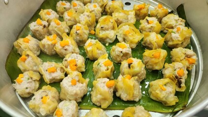 Delicious Steamed Dumplings on Banana Leaves in Traditional Steamer