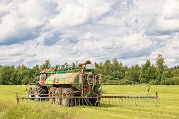 Tractor fertilizing a field a sunny summer day