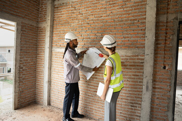 Two Engineer builder. Foreman use notebook computer and walkie talkie working in construction site.	