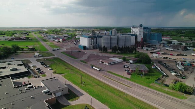 Aerial drone shot of a grain elevator and silos along a highway in Fargo, North Dakota, showcasing rural agribusiness infrastructure.