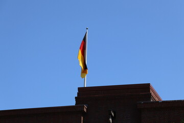 German Flag on Building Against Blue Sky