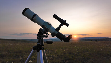 Preparing for night sky observing with a astronomical telescope just before sunset in the countryside.
