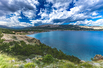 Hiking trail leading from the beach in Baska to the Bag mountain, city panorama seen from above,