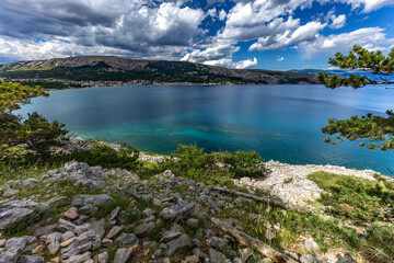 Naklejka premium Climbing the Bag peak on the island of KRK, a view of the panorama of the city of Baska, sharp rocks,