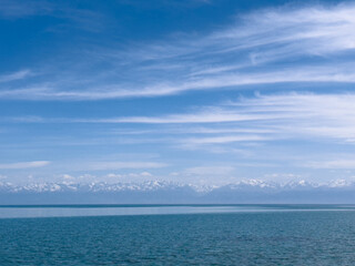 Evening calm and smooth lake surface under soft clouds
