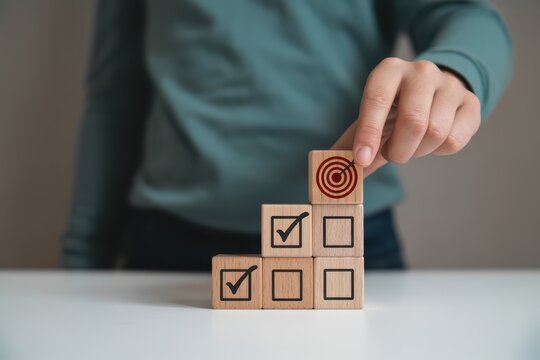 Wooden blocks with target and check marks, illustrating a goal-oriented approach.