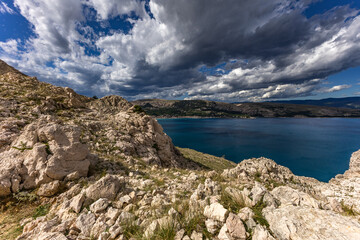 Climbing the Bag peak on the island of KRK, a view of the panorama of the city of Baska, sharp rocks,