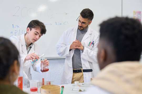 Chemistry students and teacher making experiments in laboratory