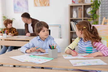 Fototapeta premium Kids with teacher at painting lesson indoors, selective focus. Learning to draw