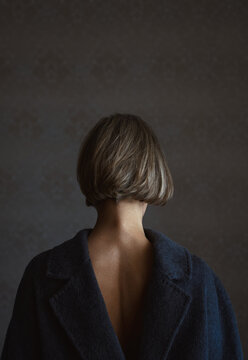 Back view on a blond woman wearing coat vice versa