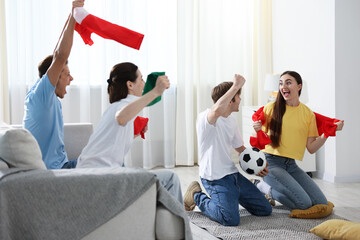 Emotional football fans watching game together indoors