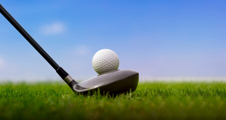 golf club and golf ball on pin in a green lawn with morning sunshine.