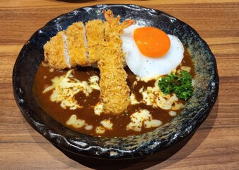 Delicious Curry Dish with Fried Shrimp and Egg on Wooden Table