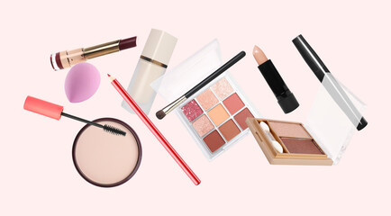 Different makeup products flying against pale pink background
