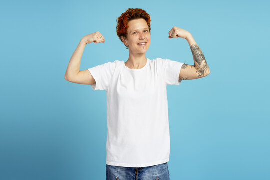 Young person flexing biceps showing strength and confidence