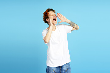Enthusiastic person shouting with hands cupped around mouth on blue background