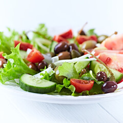 Healthy and tasty salad with , various tomatoes, olives, cucumber, onion and lettuce.	