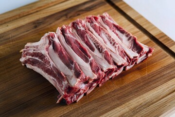 A photo of raw ribs on a wooden cutting board.