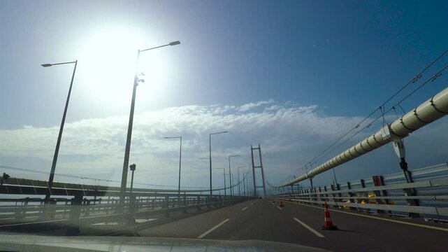 Vehicle crossing osman gazi bridge on a sunny day. Osman gazi bridge, illuminated by bright sunlight, supports a vehicle driving across its expanselandscape
